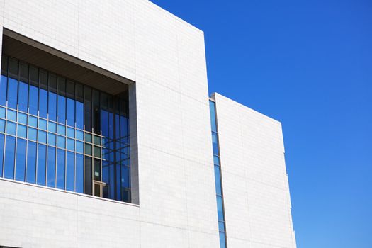 Bright new building with blue green windows against a clear blue sky