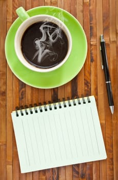 green cup of hot coffee and note paper on wood background