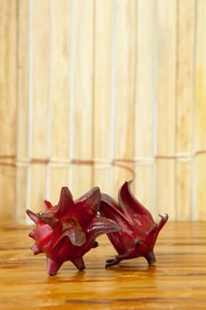 Hibiscus sabdariffa or roselle fruits on wood background