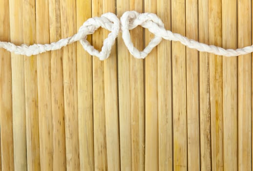 Rope in the shape of heart isolated on wood background