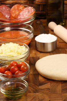 pizza ingredients and utensils  on  wood cutting board 