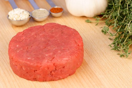 fresh raw beef burger patty,  with ingredients on background 