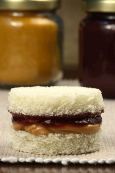 fancy and yet simple  peanut butter and jelly sandwich with jars on background  