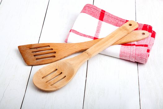 Wooden kitchen set with tea towel, on wooden white background.