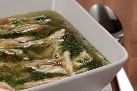 chicken breast and vegetables soup  made with low sodium  broth,  on fine wood table table.