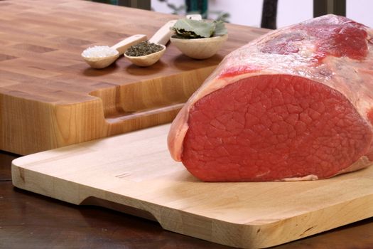 raw fresh and juicy eye of round roast steak or beef  with ingredients on background  perfect for baking and roasting