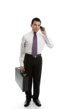 A businessman carrying a black briefcase and using a mobile cell phone.