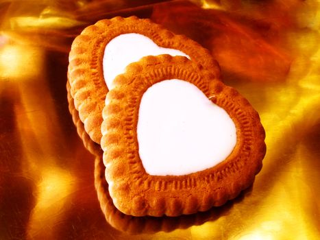 two heart-shaped biscuits over golden background