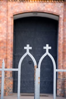 church steel gate and fragment of entrance. religious symbol cross and building.