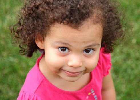 beautiful biracial little girl posing with grin