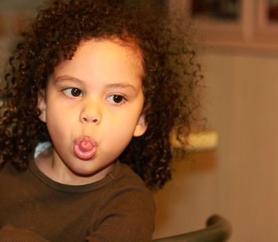 biracial little girl making funny face sticking out her tongue