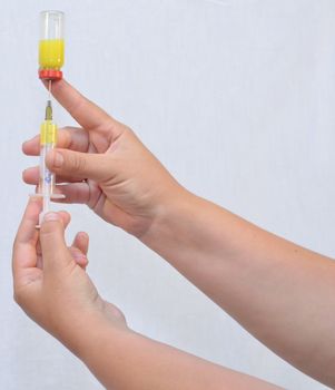 On white background, are made hands, medication, syringe.