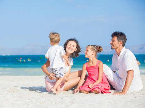 Family of four having fun on tropical beach