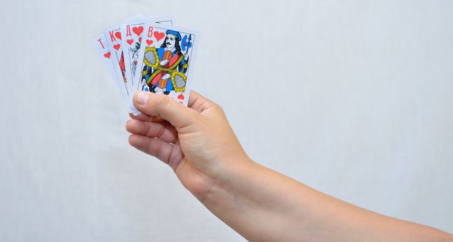 On white background, the photo of the hand with playing cards.