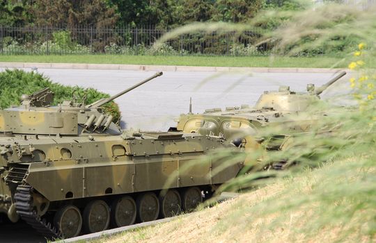 Moving armored  column against green grass background