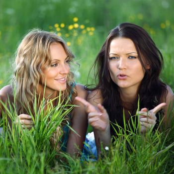 girlfriends lays on green grass and smile