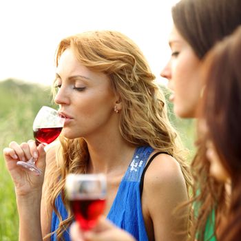 girls drink wine on nature background