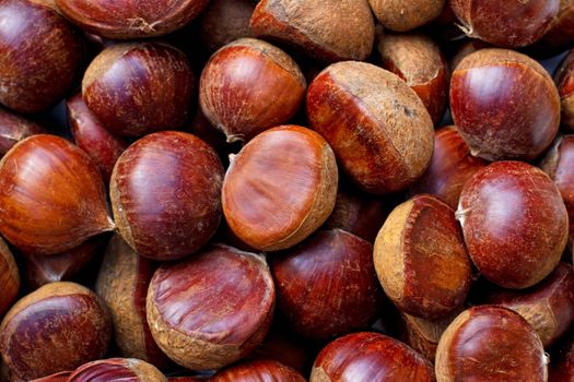 A background of raw and unpeeled chestnuts