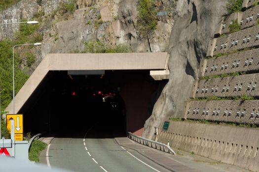 A tunnel on the A55 expressway, North Wales, UK, with a walkway and an engineered retaining wall with steel pins.