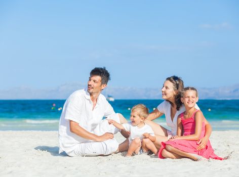 Family of four having fun on tropical beach