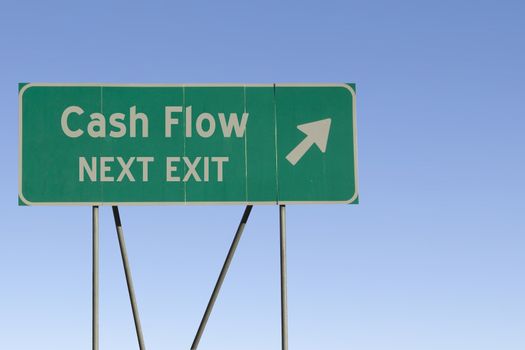 Green road sign with a blue sky gradient background.