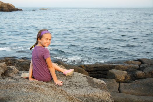 Little girl siting by the sea in Maine