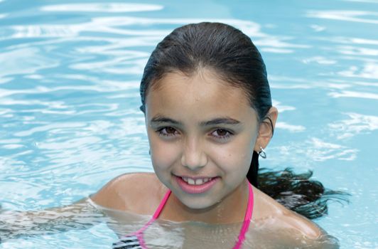 Young girl swimming on blue swimming pool