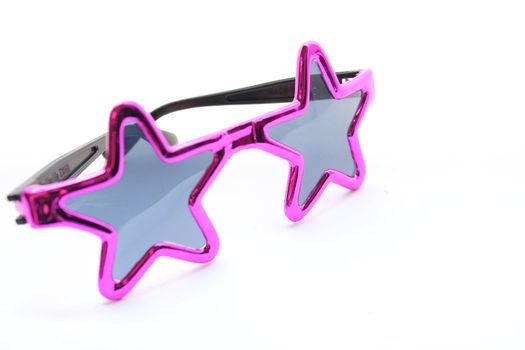 Pink star sunglasses for toddler at the beach.
