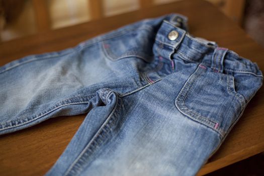 Detail of Denim blue jeans pocket on wood tabletail of Denim blue jeans pocket on wood table