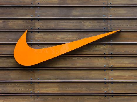 Orange Nike logo on a wooden wall