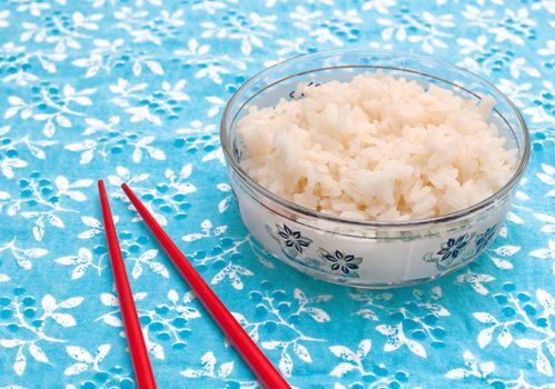Boiled rice with butter on a tablecloth with chopsticks
