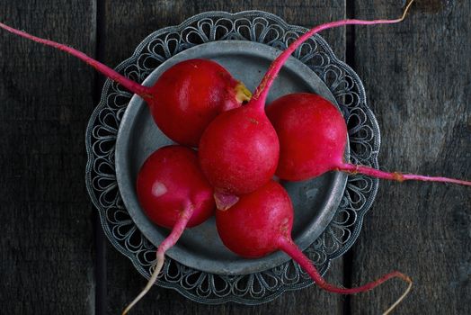 Radish on a metal plate on the wooden table