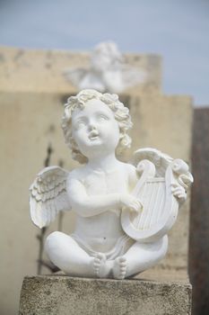 Guarding angel playing the harp on a cemetery in the Provence, France