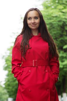 Brunette woman with long hair and red trench outdoor