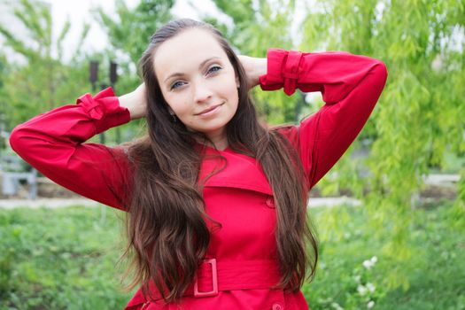 Brunette woman with long hair and red trench outdoor