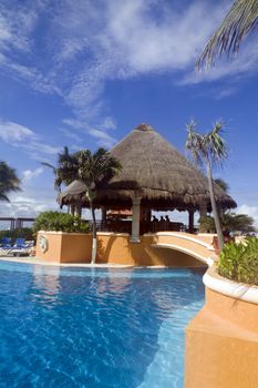 A resort pool with blue waters and a bar