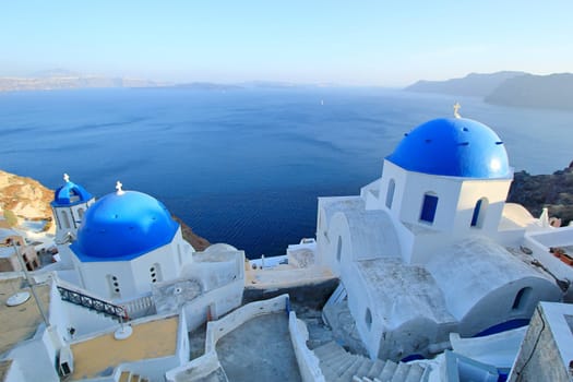 Famous Blue Domes of orthodox churches on the sea background in Santorini island, Greece.