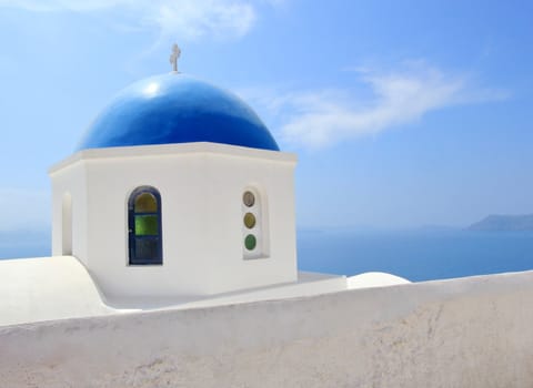 Blue dome and cross of a greek orthodox church in Santorini island, Greece, by beautiful weather