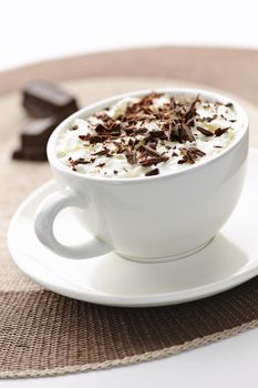 Cup of hot cocoa with shaved chocolate and whipped cream