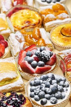 Background of assorted fresh sweet tarts and pastries