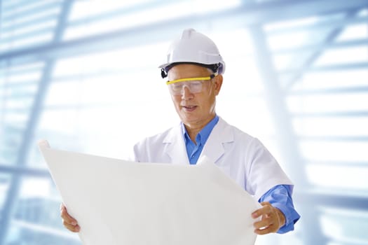 Senior Asian engineer with blueprints office background