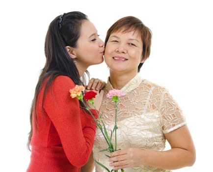Mixed race asian daughter giving a kiss to her mum isolated on white