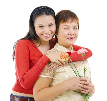 Asian mother holding carnation flower with her daughter isolated on white background