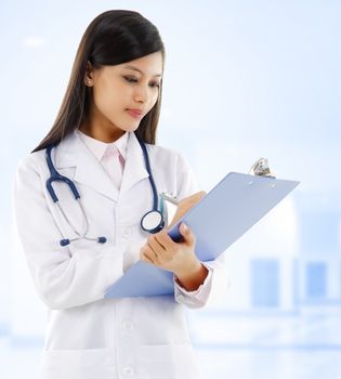 Young Asian female doctor writing medical report