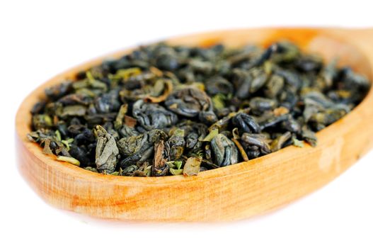 Natural green tea leaves in wooden spoon. Shallow depth of field.