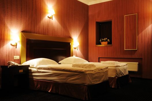 Hotel room with two beds and light on wall