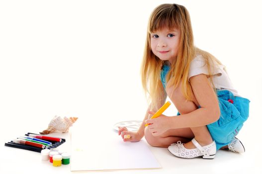 Nice girl with blonde long hair is painting on white background