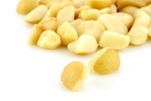 fresh organic macadamia nuts on white background 
 shallow D.O.F