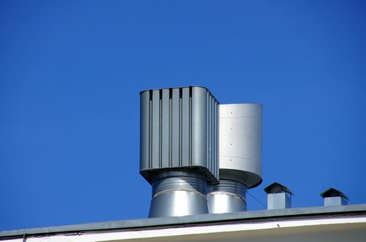 Pipe of ventilation are located on a roof of a  building