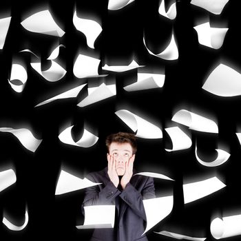 Despaired businessman with paperwork falling everywhere isolated on black background